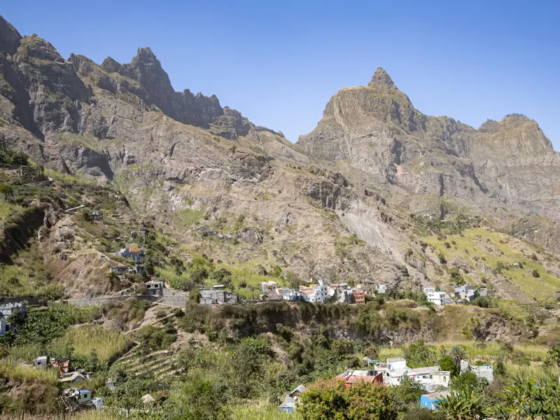 Farbenfrohes Bergdorf in einem grünen Tal am Fuße der zerklüfteten Vulkanberge auf der Wanderinsel Santo Antão, Kapverden.