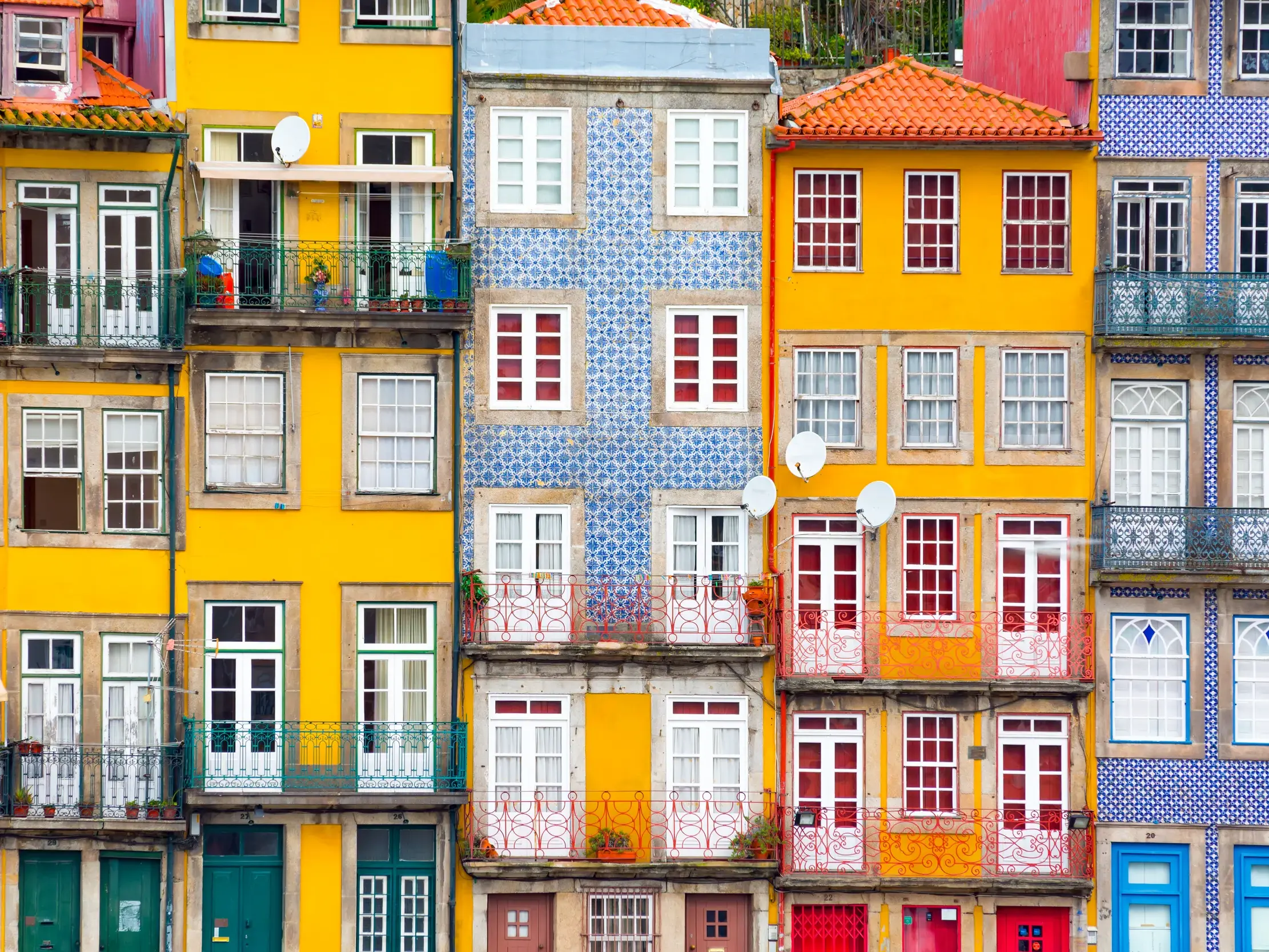 Lebhafte, bunte Häuserfassaden mit kleinen Balkonen im historischen Ribeira-Viertel von Porto, Portugal.