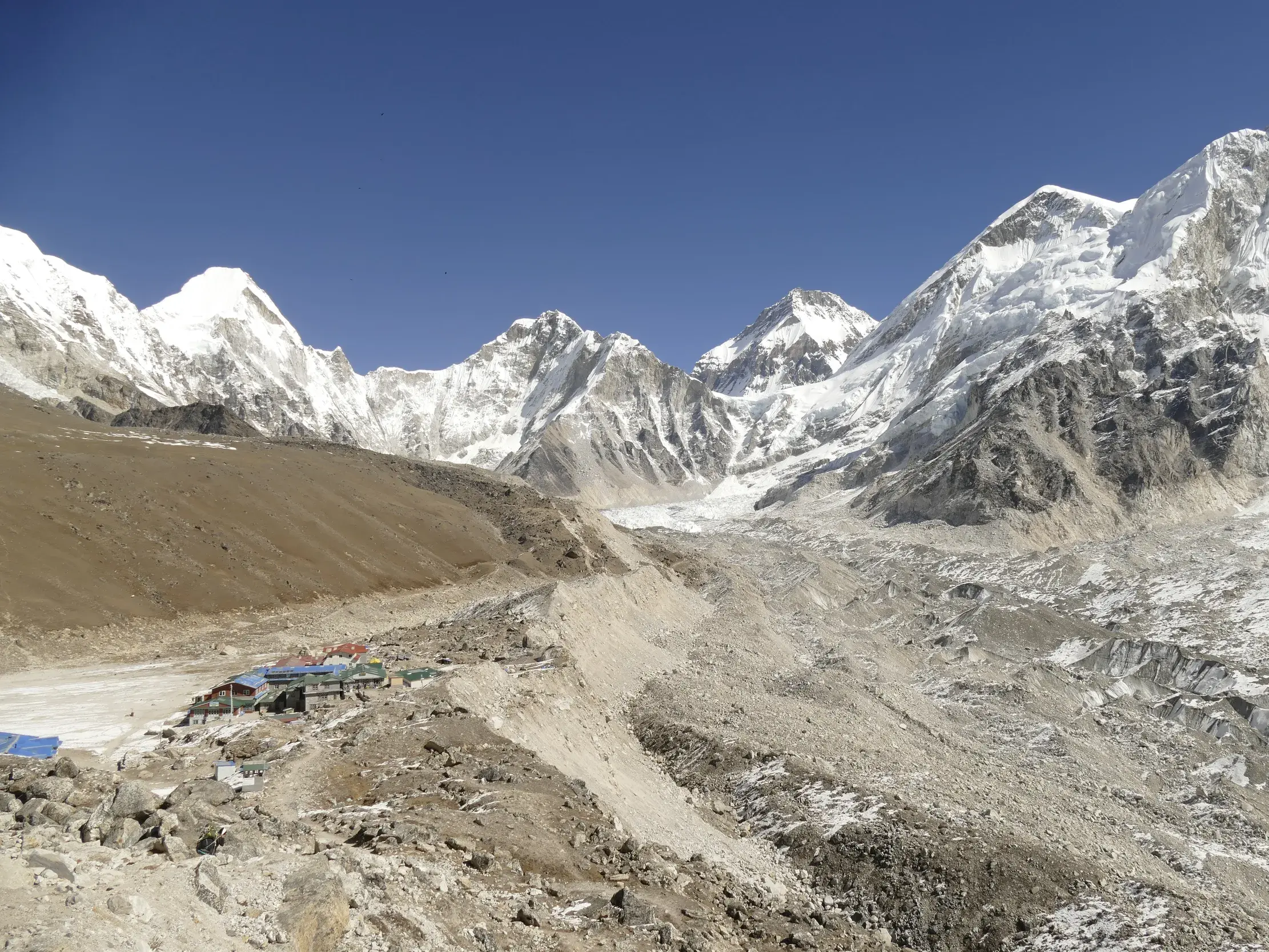 Panoramablick auf die Lodges von Gorak Shep am Khumbu-Gletscher vor der Kulisse schneebedeckter Himalaya-Gipfel in Nepal.