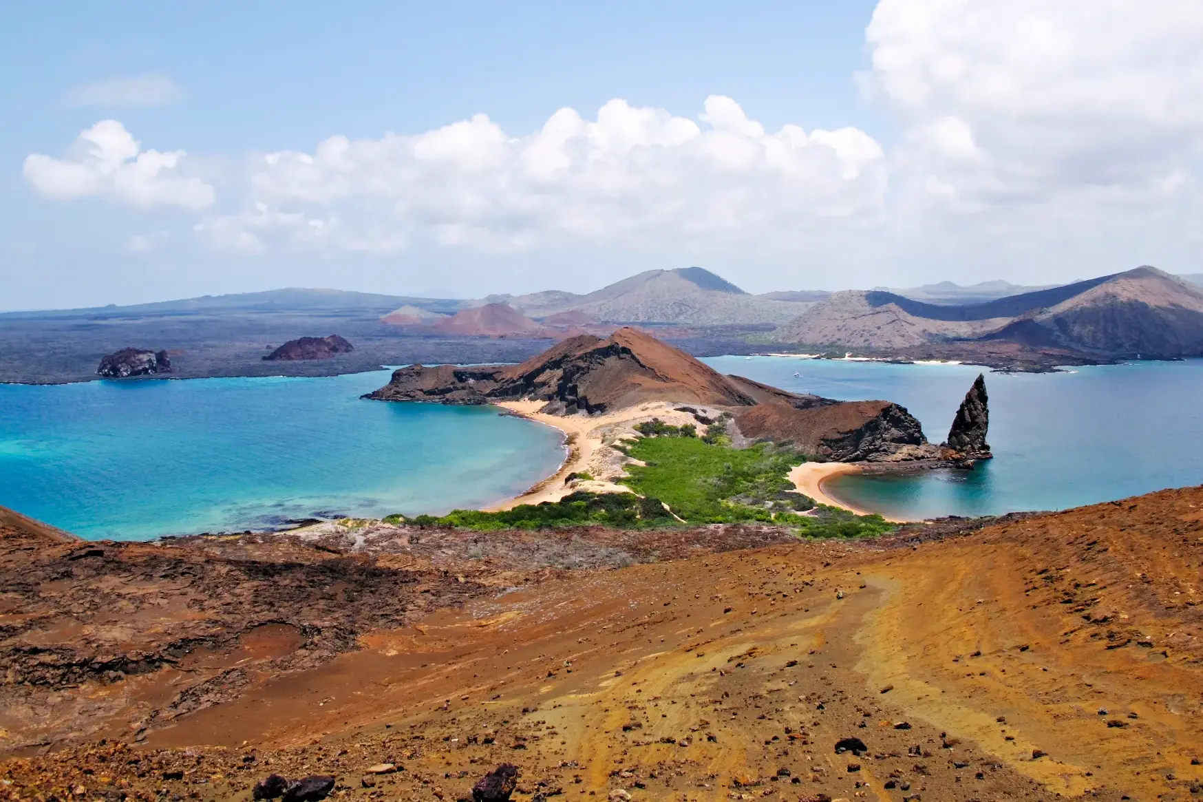 Panoramablick auf die Vulkaninsel Bartolomé mit dem Pinnacle Rock, türkisfarbenem Wasser und schwarzen Lavafeldern auf Galápagos.