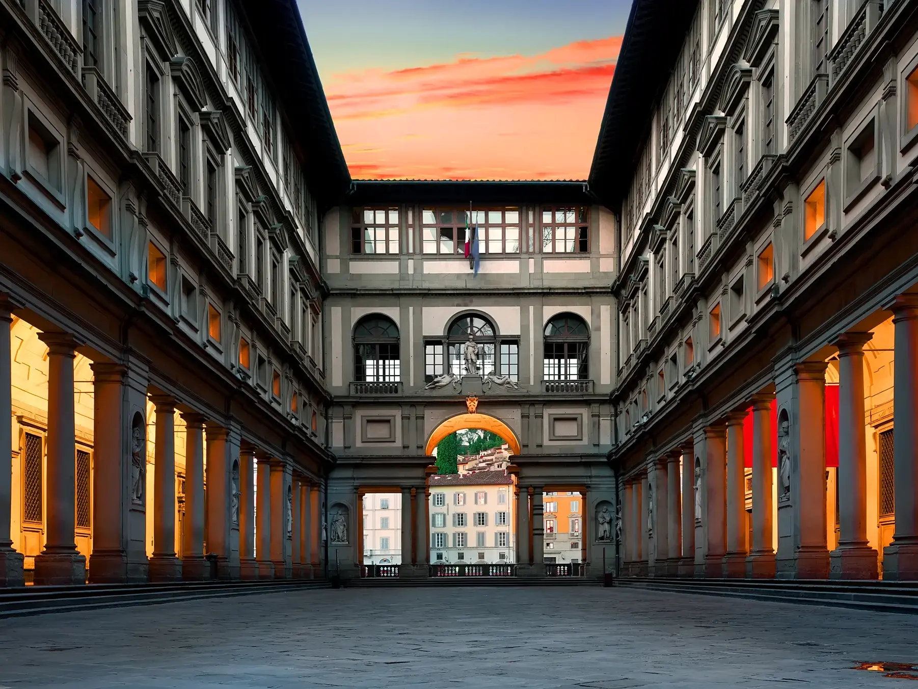 Der menschenleere, symmetrische Innenhof der Uffizien in Florenz im warmen Licht des Sonnenuntergangs.