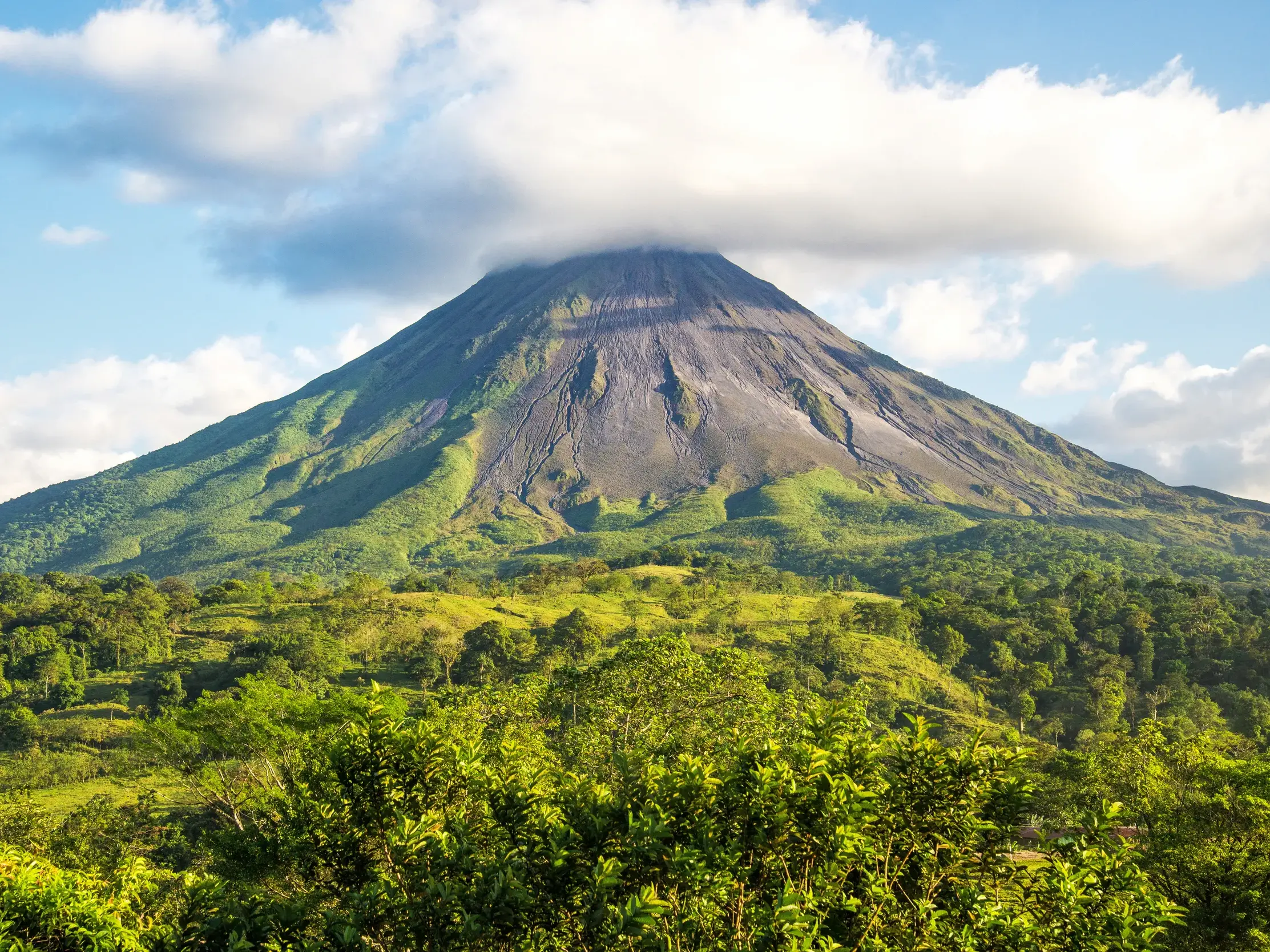 Der formschöne Vulkankegel des Arenal in Costa Rica, umgeben von der üppigen Vegetation des tropischen Regenwaldes.