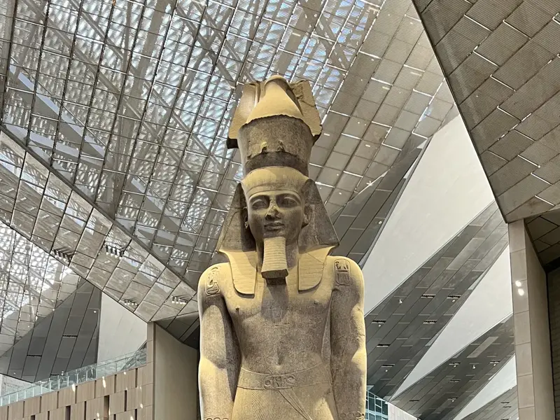 Imposante, hohe Statue des Pharao Ramses II. in der lichtdurchfluteten Halle des Grand Egyptian Museum in Gizeh.