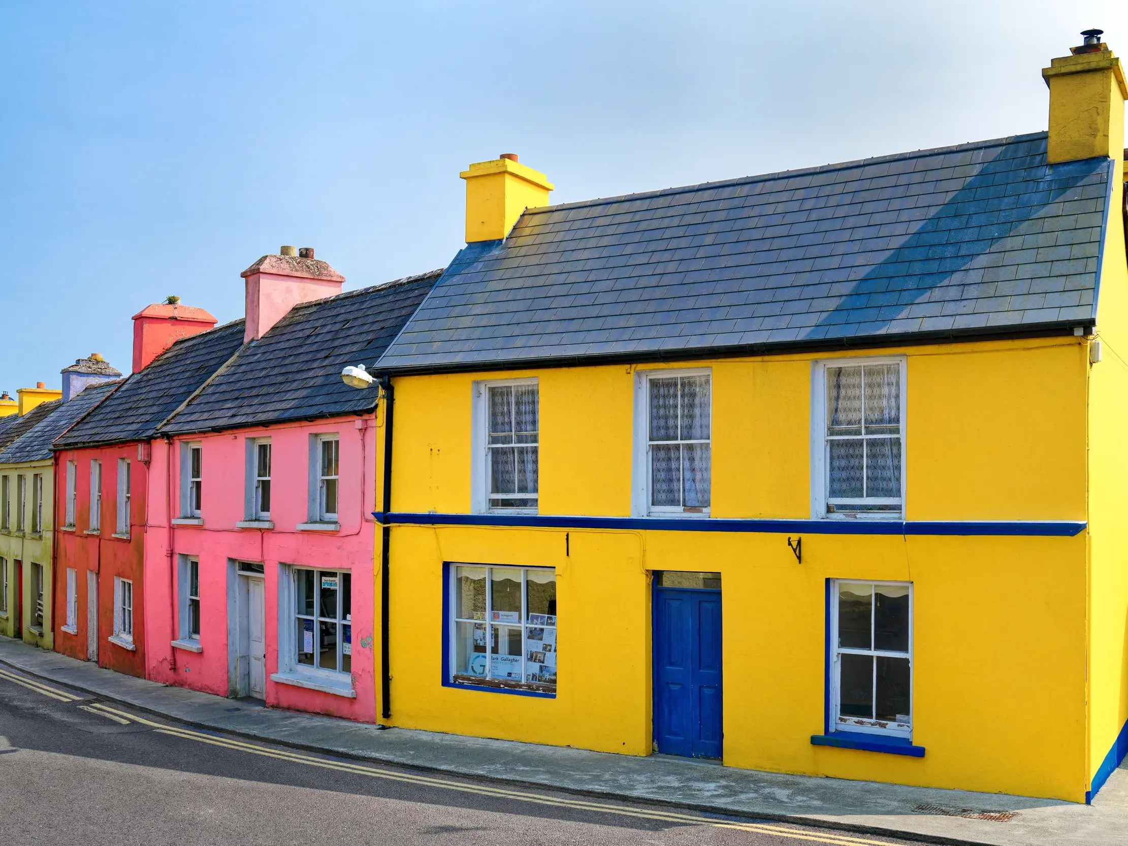 Bunte und farbenfrohe Häuserzeile mit einer gelben Fassade in Dingle Town auf der Halbinsel Dingle in Irland.