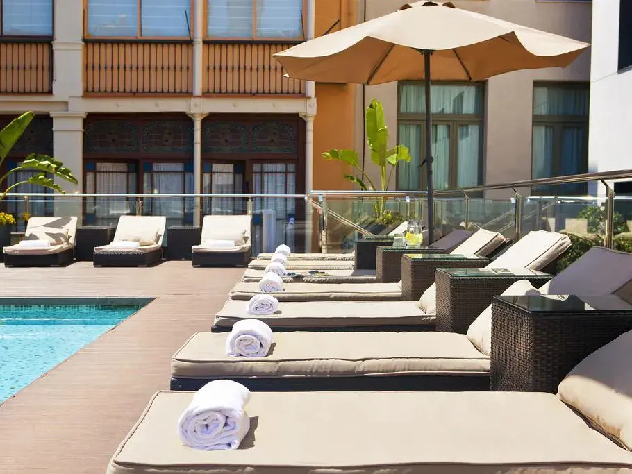 Einladende Sonnenterrasse mit Pool und Liegen im Grupotel Gran Vía 678 für entspannte Momente in Barcelona.