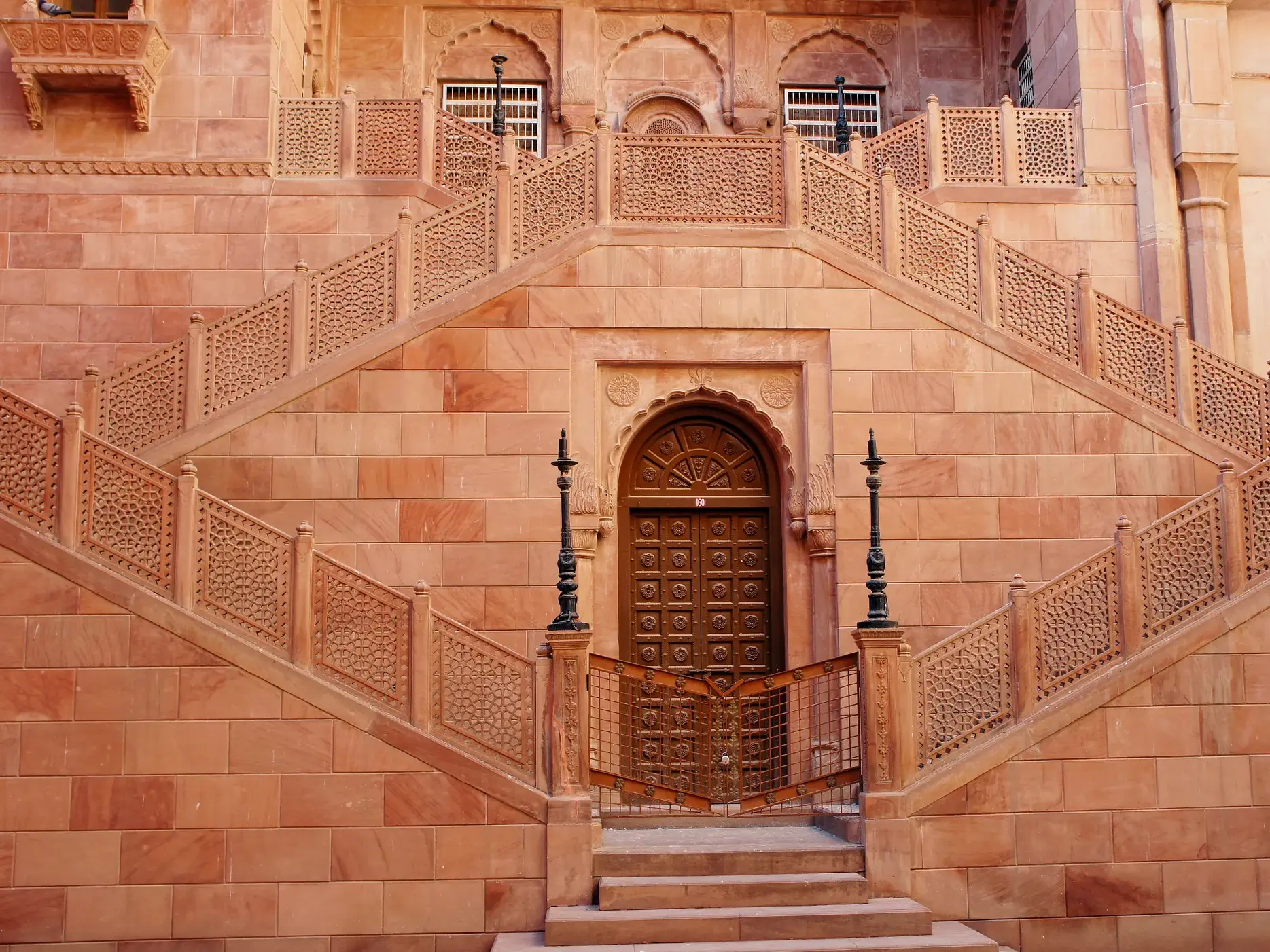 Symmetrische Treppe aus rotem Sandstein mit filigranen Jali-Schnitzereien im Mehrangarh Fort in Jodhpur, Rajasthan.