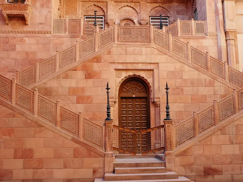 Symmetrische Treppe aus rotem Sandstein mit filigranen Jali-Schnitzereien im Mehrangarh Fort in Jodhpur, Rajasthan.