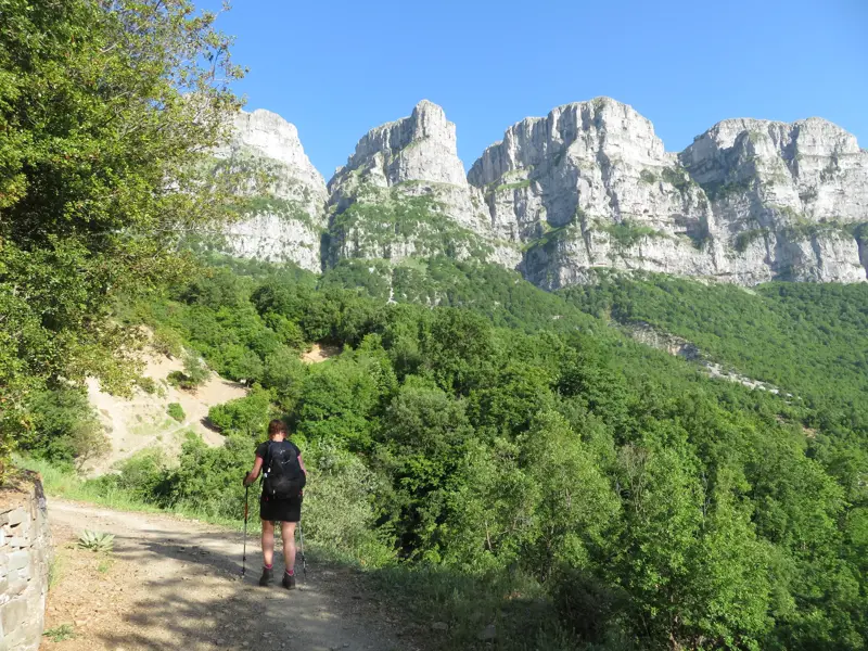Wanderin auf einem Bergpfad in der Zagori-Region mit Blick auf die massiven Kalksteintürme von Astracha.