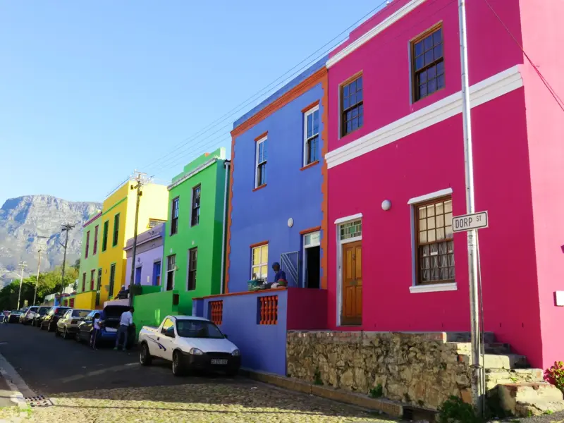 Sonniger Tag in Kapstadt: Farbenfrohe Häuser im historischen Viertel Bo-Kaap, im Hintergrund der markante Tafelberg.