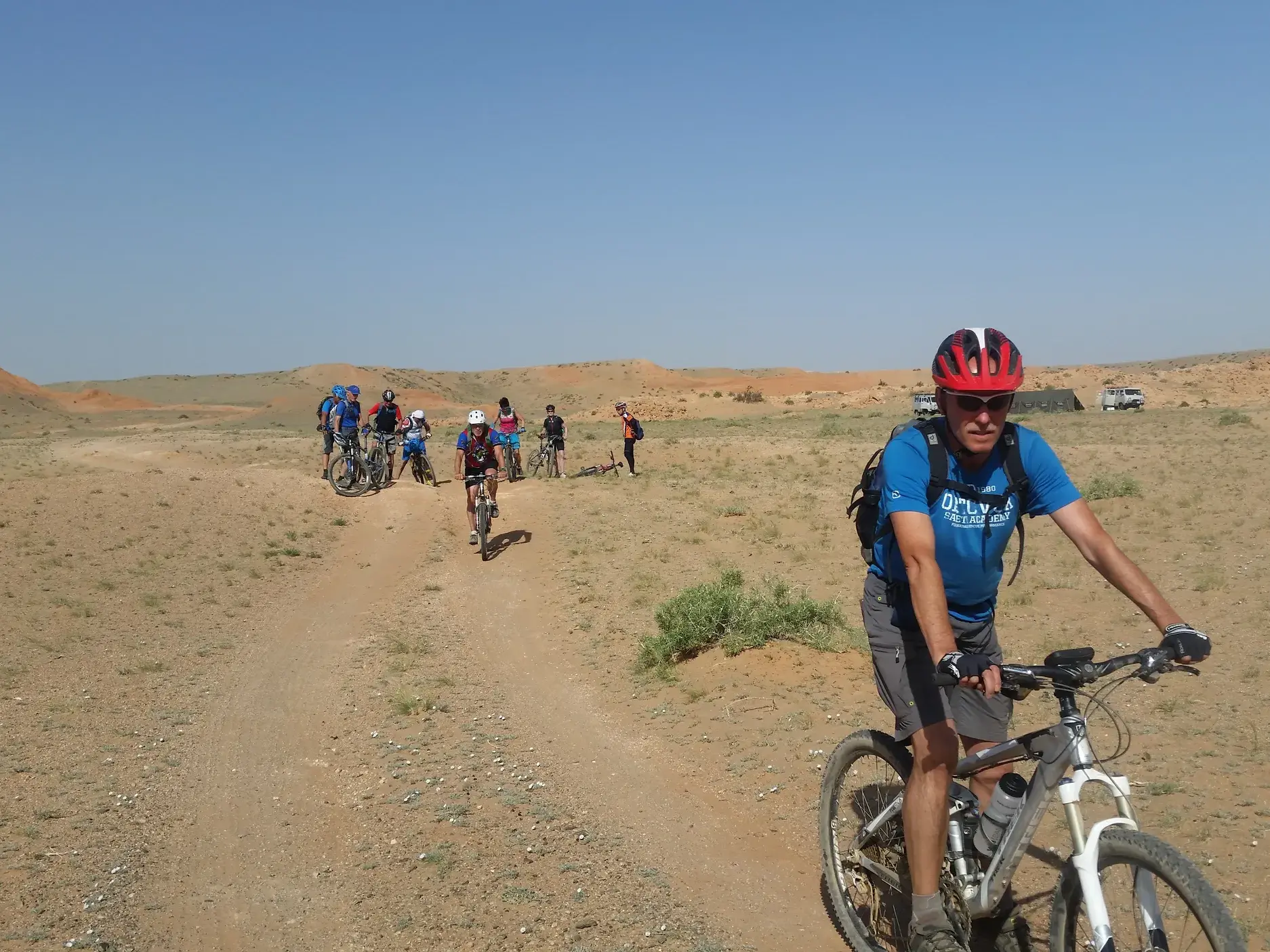 Eine Hauser-Reisegruppe erkundet mit Mountainbikes auf einem Trail die weite, sonnige Steppenlandschaft der Mongolei.