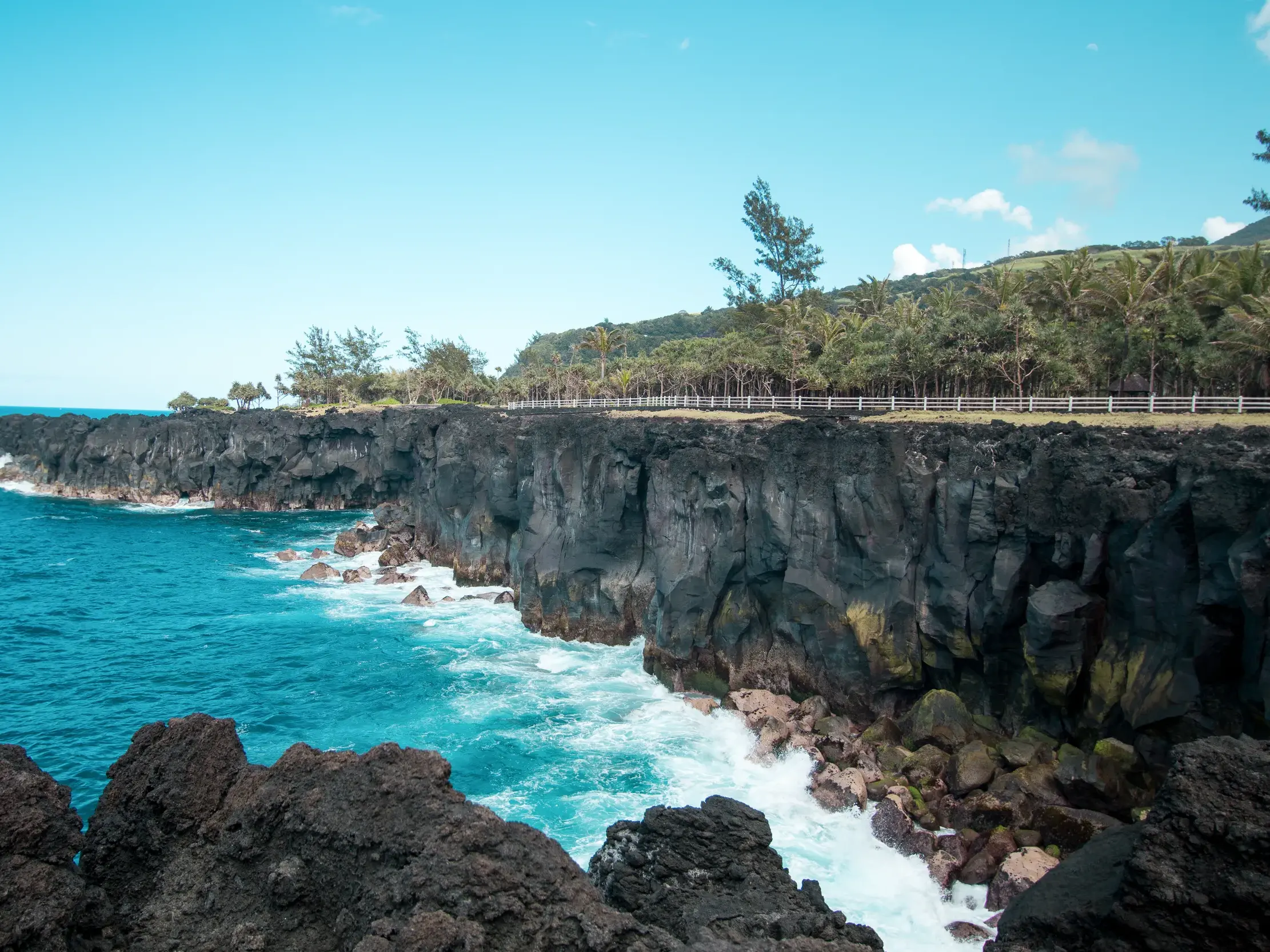 Wellen des Ozeans schlagen gegen pechschwarze Lavaklippen am Cap Méchant an der wilden Südküste von La Réunion.