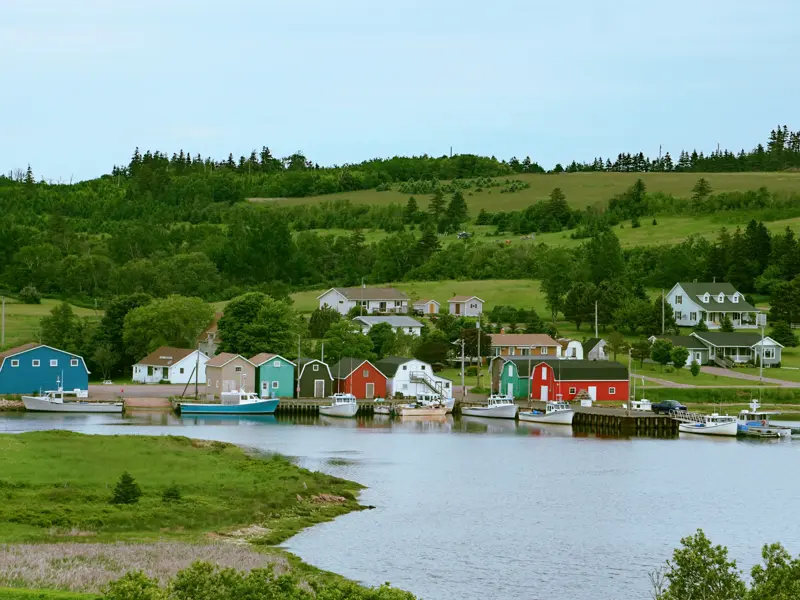 Idyllisches Fischerdorf mit bunten Holzhäusern und Booten am Ufer im Prince Edward Land in Ostkanada.