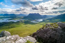 Felsiger Gipfel bietet weite Aussicht auf die Seen und Berge von Wester Ross in den schottischen North West Highlands.