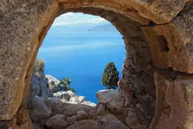 Panoramablick durch einen Steinbogen der Palamidi-Festung in Nauplia auf die tiefblaue Bucht von Argolis.