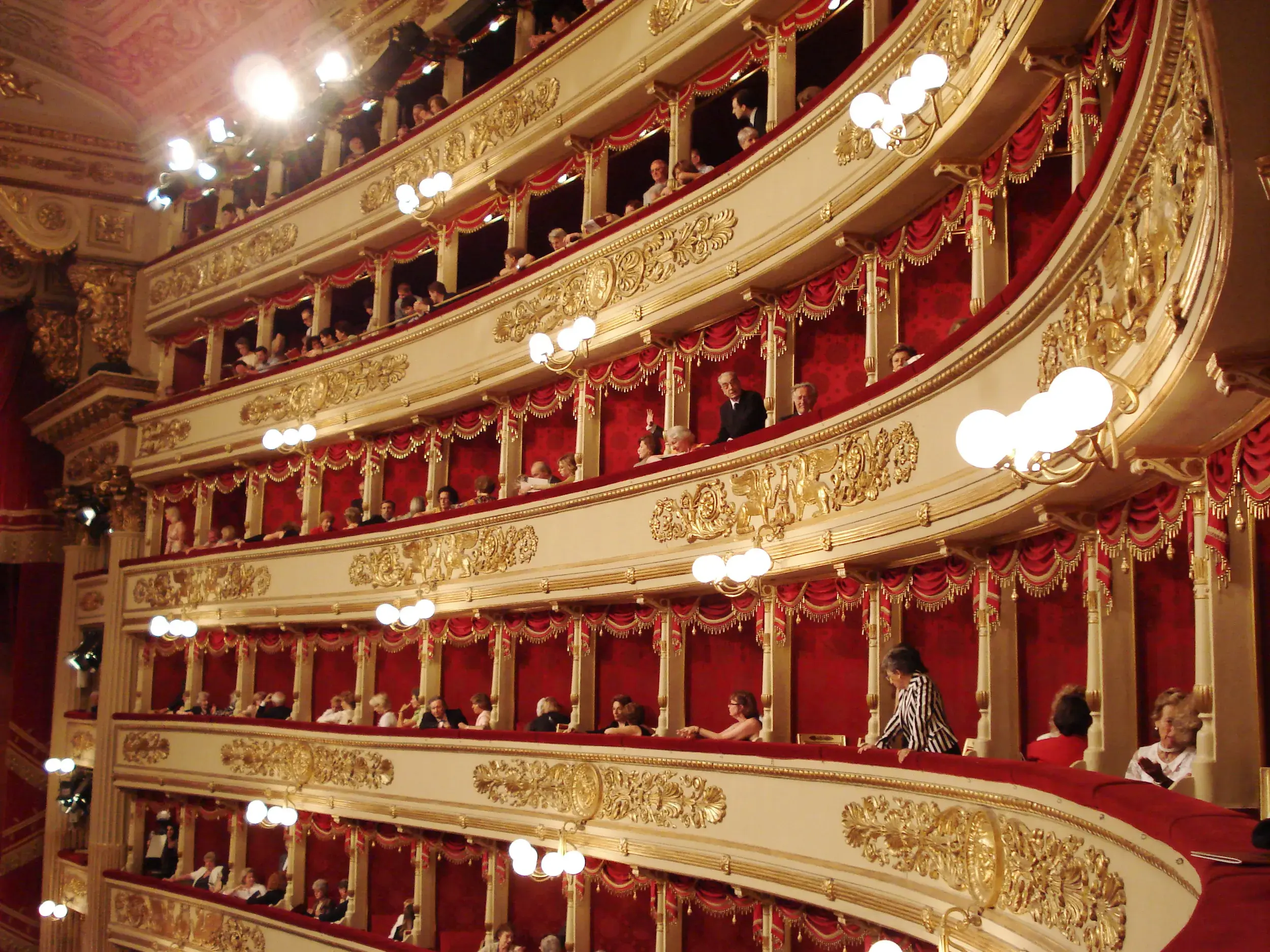 Festlich beleuchtete, goldverzierte Logen mit Publikum im Opernhaus Scala in Mailand