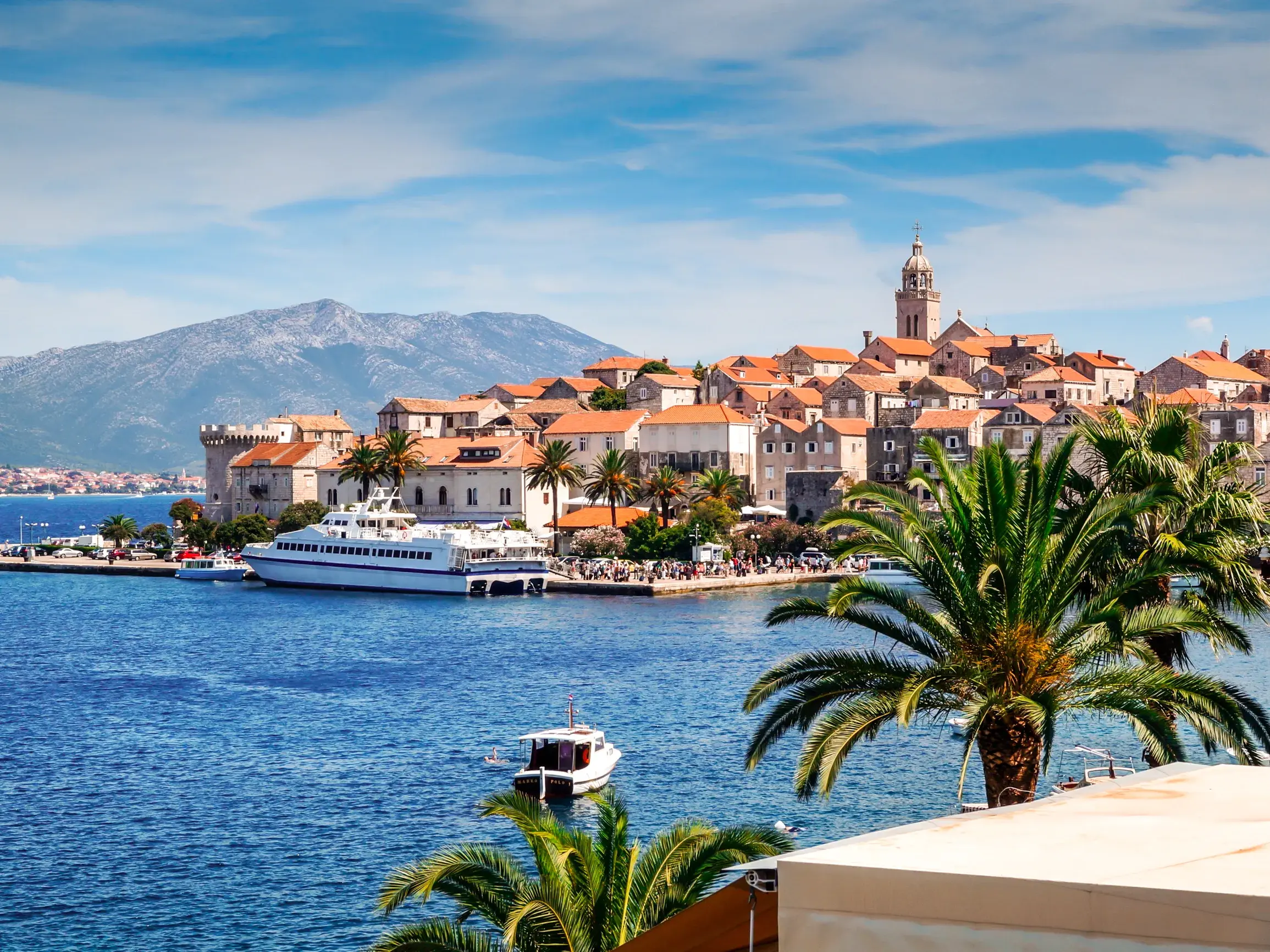 Malerischer Blick auf die historische Altstadt von Korcula-Stadt an der Adria, eine Fähre im Hafen und die Halbinsel Peljesac.