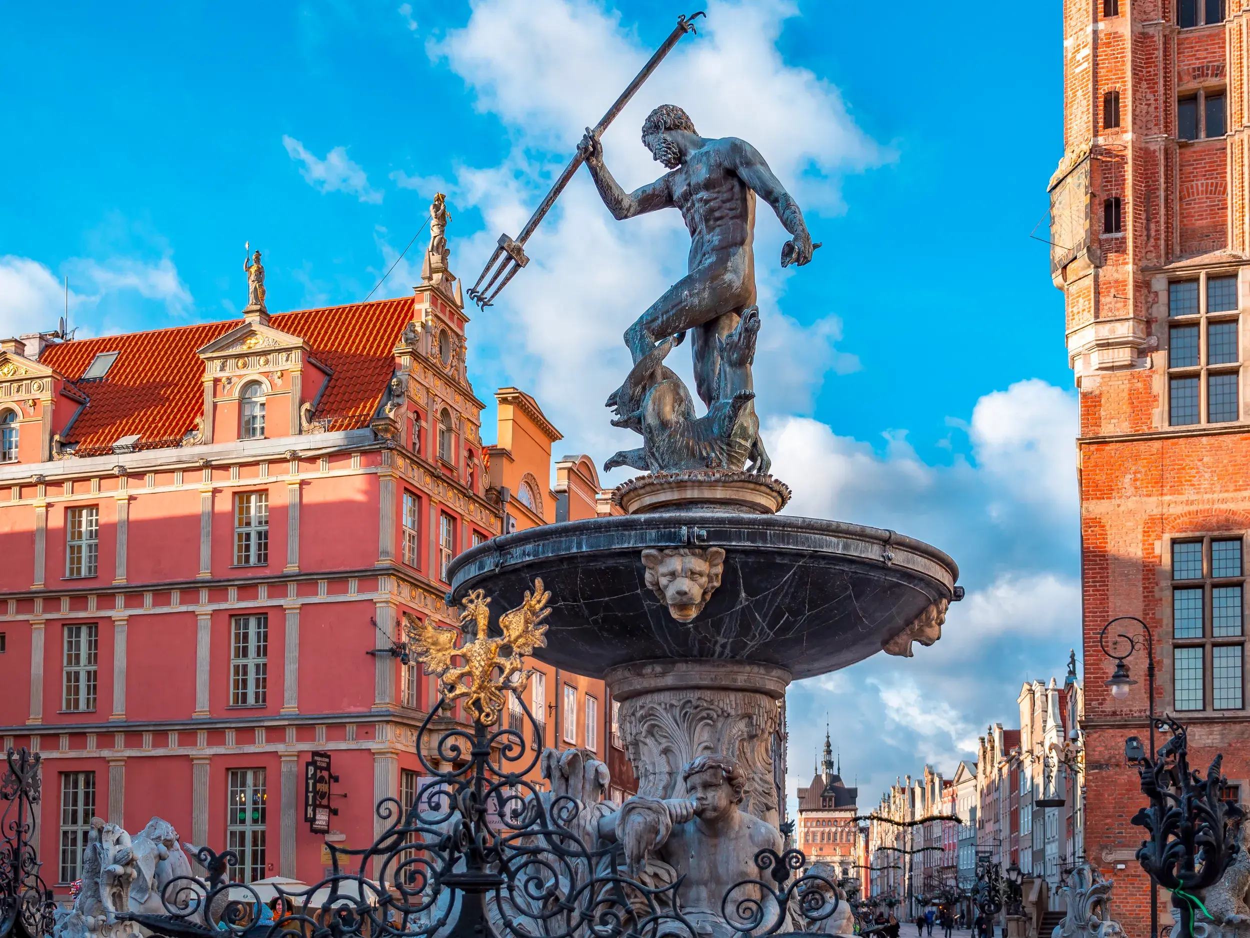 Die Statue des Neptunbrunnens auf dem Langen Markt in Danzig, im Hintergrund die eleganten Patrizierhäuser der Hansestadt.