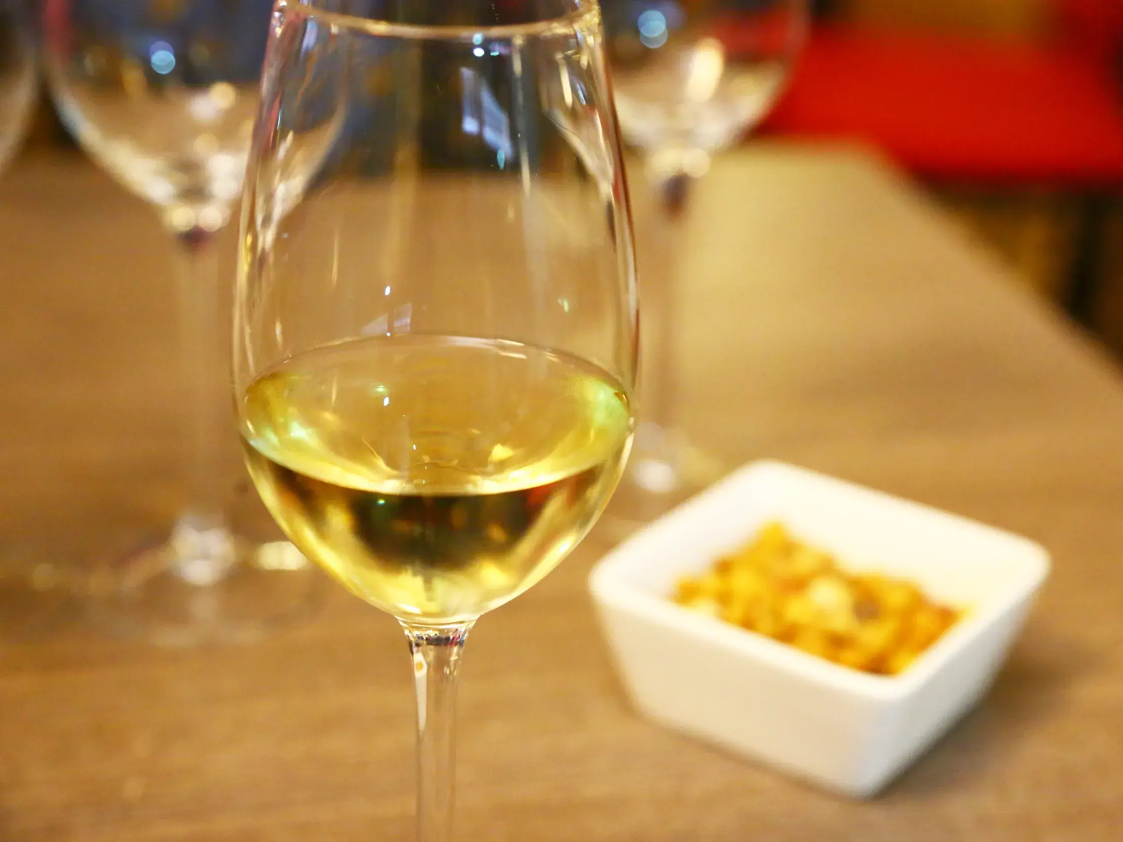 Ein Glas mit goldenem Sherry steht auf einer Theke