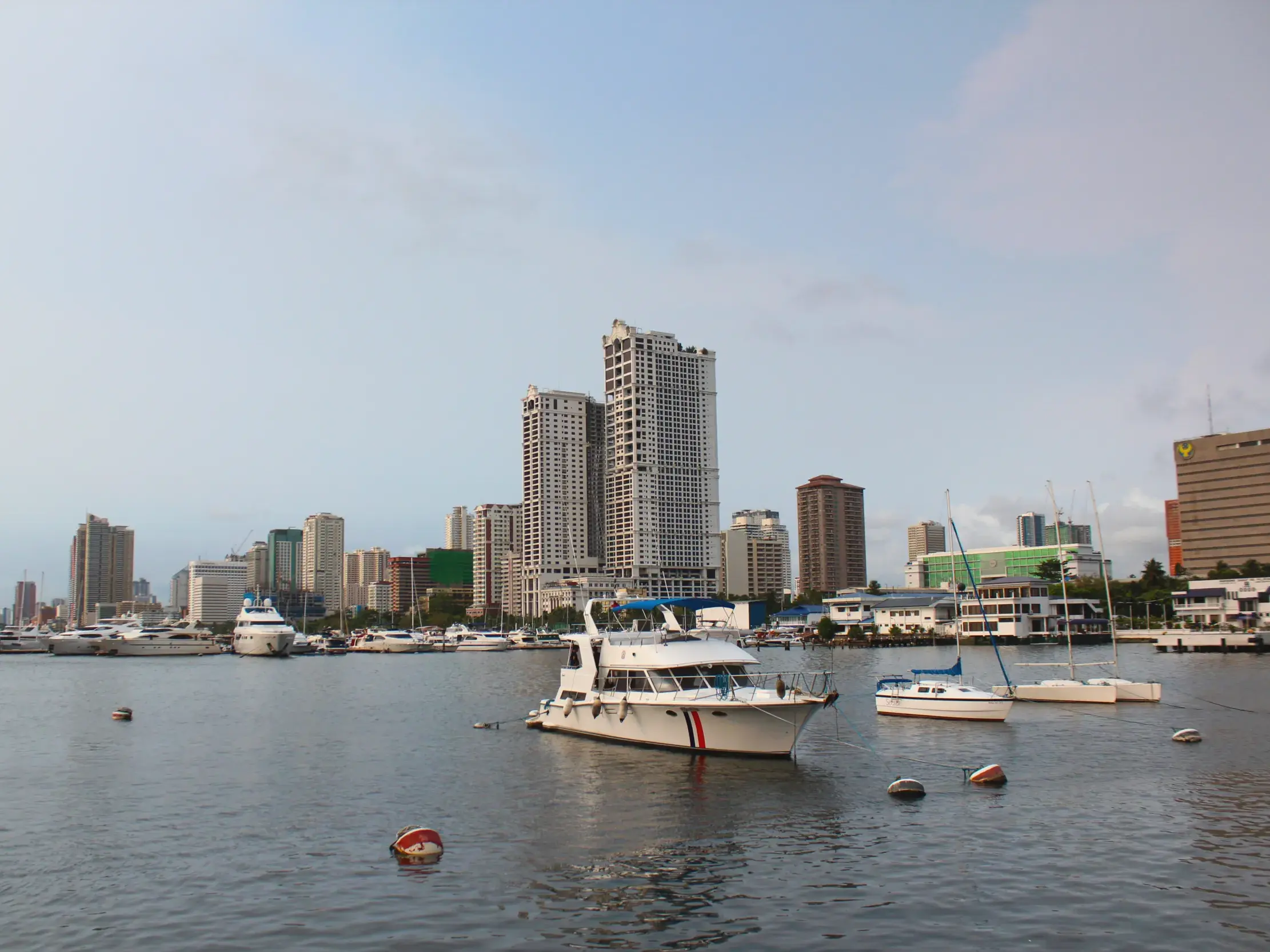 Zahlreiche Yachten und Boote ankern im Hafen von Manila vor der beeindruckenden Skyline der philippinischen Hauptstadt.