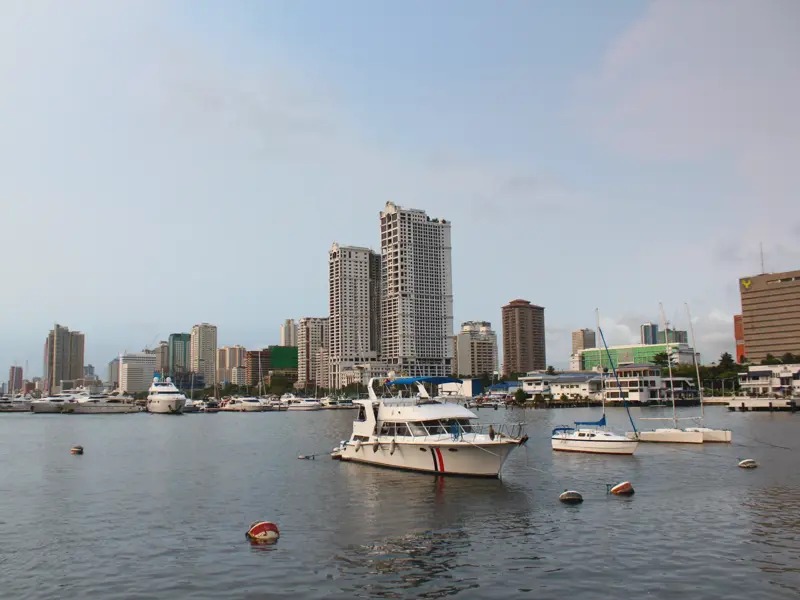 Zahlreiche Yachten und Boote ankern im Hafen von Manila vor der beeindruckenden Skyline der philippinischen Hauptstadt.