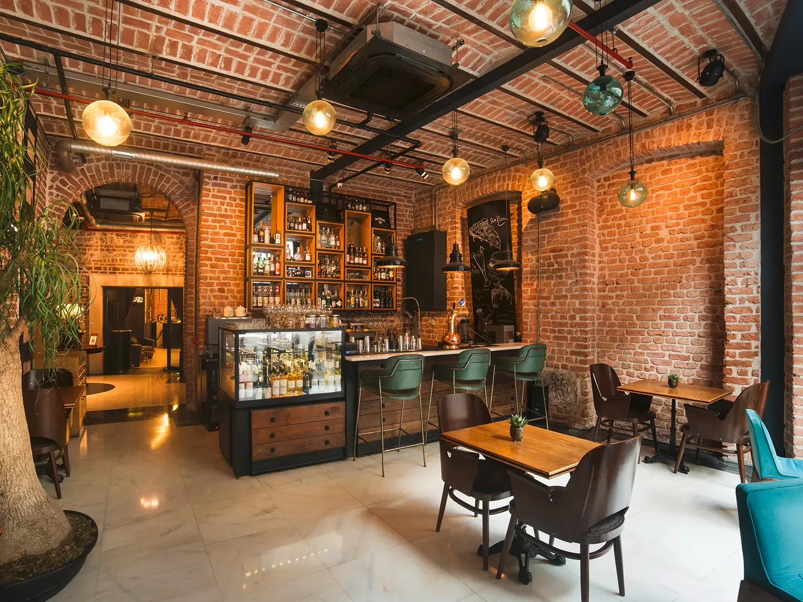 Stilvolle Hotelbar im Boutiquehotel Régie Ottoman in Istanbul mit freiliegenden Backsteinwänden und moderner Einrichtung.