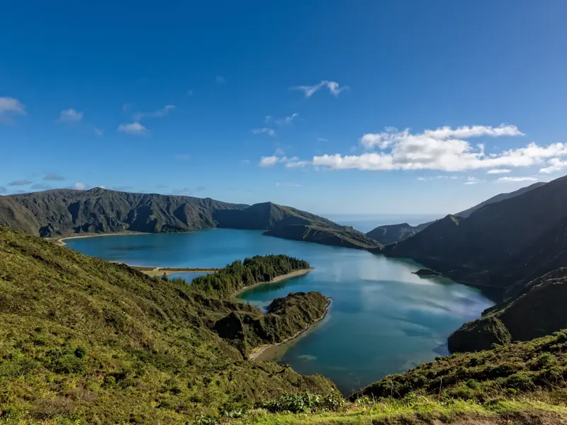 Panoramablick auf den tiefblauen Kratersee Lagoa do Fogo, umgeben von grünen Vulkanhängen auf São Miguel, Azoren.