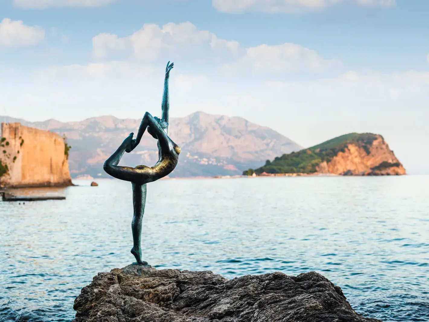 Die berühmte Tänzerinnen-Statue auf einem Felsen in der Adria vor der malerischen Altstadt von Budva in Montenegro.