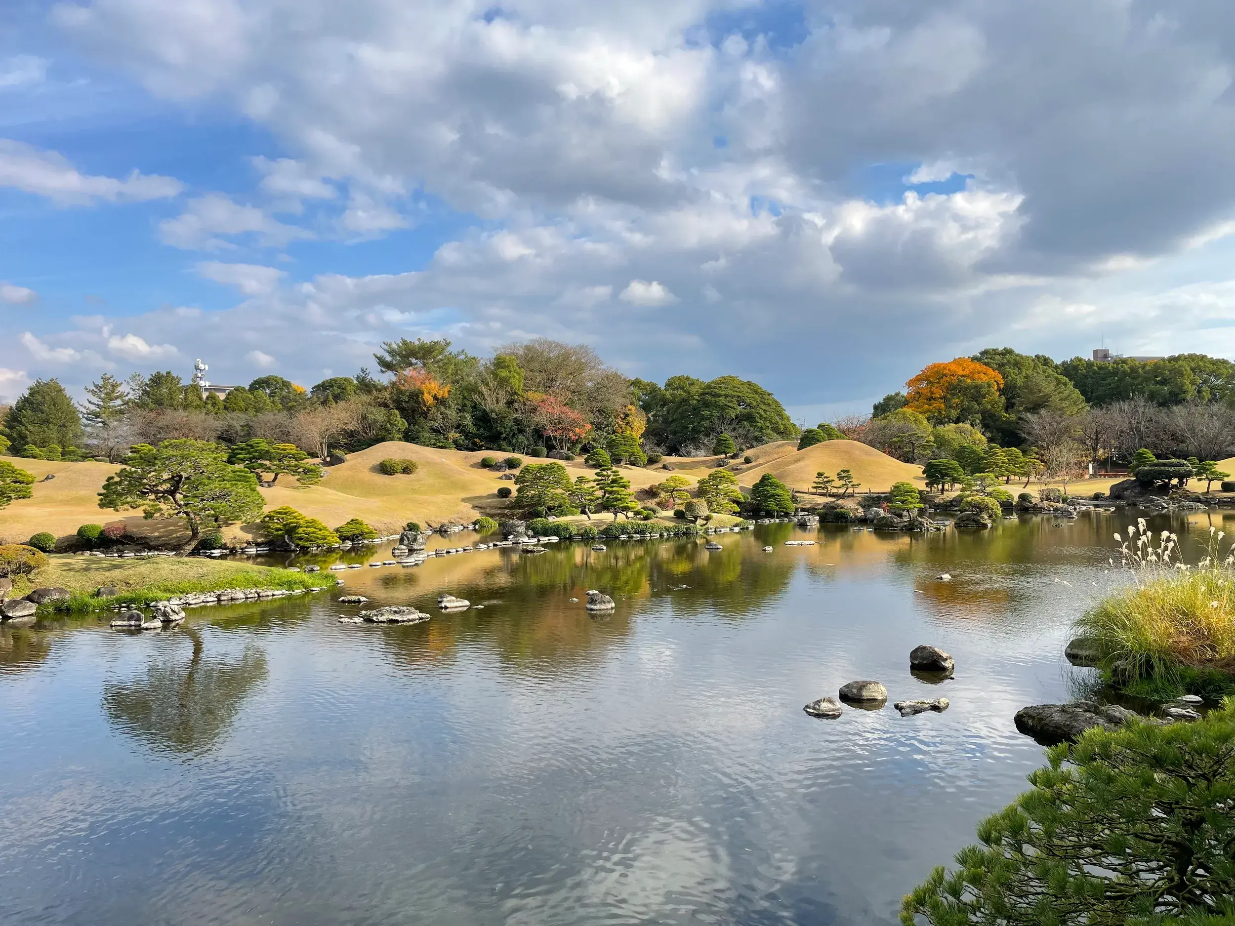Der berühmte Suizenji-Garten in Kumamoto, eine japanische Landschaftsanlage mit Teich, Miniatur-Fuji und formgeschnittenen Bäumen.