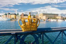 Eine goldene Krone ziert die Skeppsholmsbron vor der Kulisse der Altstadt Gamla Stan und des Königlichen Schlosses Stockholm.
