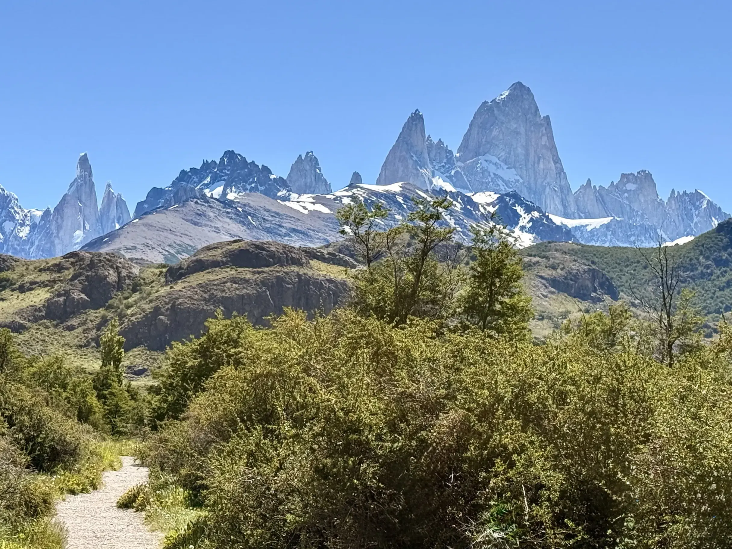 Wanderweg im Nationalpark Los Glaciares mit Blick auf die majestätischen, schneebedeckten Gipfel des Fitz Roy Massivs.